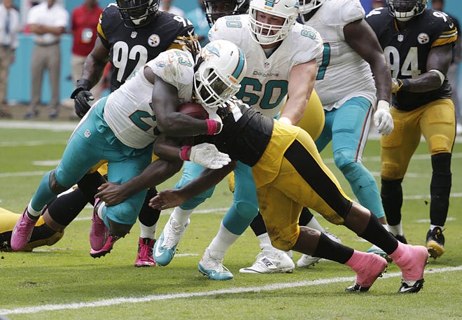 Dolphins running back Jay Ajayi (23) scores a touchdown as Steelers inside linebacker Vince Williams (98) makes the tackle during the second half of the Steelers' 30-15 loss Oct. 16 in Miami Gardens.