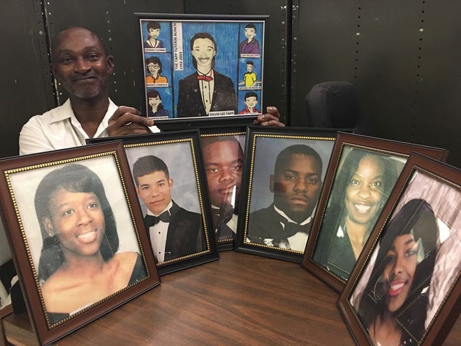 David Tapp poses with the senior portraits of his original six students.