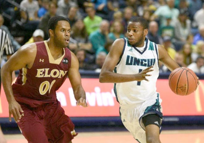 UNC Wilmington's Chris Flemmings drives on Elon's Brian Dawkins during Monday night's game at Trask Coliseum.
