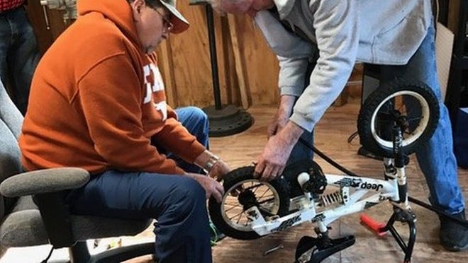 Jim Johnson and Bill Wallis help restore a dozen bikes taken from local Bastrop resale shops to deliver to needy children on Christmas Day. (CONTRIBUTED)