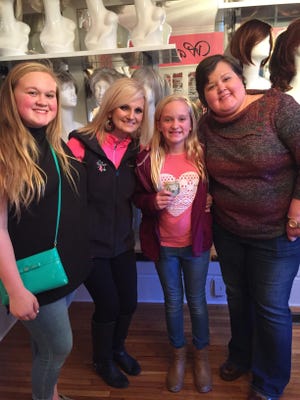 Along with her mom and sister, Riley Lavinder, 11, meets with The Woman in Pink director Kim Beverly and delivers her a donation in honor of her mom, Dawn Lavinder, who is battling cancer for the second time in two years. Pictured from left to right, Regan Lavinder, 14, Riley Lavinder, 11, Kim Beverly and Dawn Lavinder.
