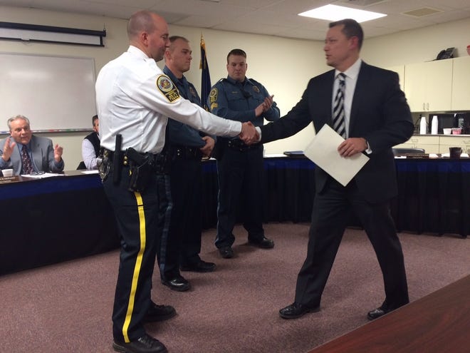 Chief Chris Wagner (in suit and tie) congratulated Christopher Vogt on Vogt's promotion from interim to full-time lieutenant at the Thursday, Jan. 5, 2017, Pocono Mountain Regional Police Commisioners' meeting. Cpl. Nicholas Mecca (in blue uniform beside Vogt) was promoted to sergeant and Detective Rob Miller (in blue uniform beside Mecca) was promoted to corporal. (Andrew Scott/Pocono Record)