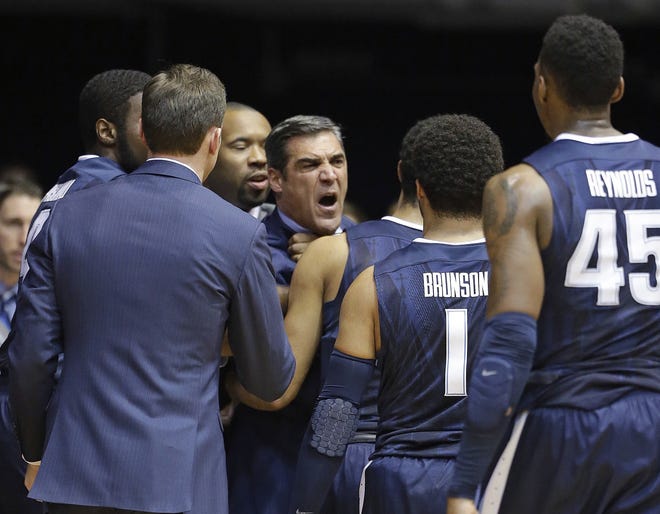 Villanova head coach Jay Wright is restrained by players during Wednesday night's loss to Butler. It was the team's first loss of the season. (AP Photo/Michael Conroy)