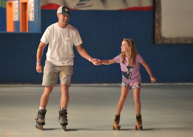 Jason Mantooth holds hands with his daughter Mary Elizabeth as they skate Tuesday at Skater's Choice. PATTI BLAKE/THE NEWS HERALD