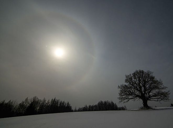 The winter Moon sometimes displays a halo on frosty nights. Jupiter is to the left of the Moon, Feb. 3, 2015. Martin Mark/Wikimedia Commons