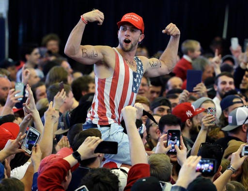 FILE - In this April 15, 2016, file photo, a Donald Trump supporter flexes his muscles with the words "Build The Wall" written on them as Trump speaks at a campaign rally in Plattsburgh, N.Y. Congressional Republicans and Donald Trump's transition team are exploring whether they can make good on Trump's promise of a wall on the U.S.-Mexico border without passing a new bill on the topic, officials said Thursday, Jan. 5. (AP Photo/Elise Amendola, File)