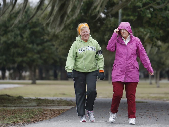 Blustery winds and the temperature in the low 50s did not stop Beverly Lynne, left, and Maggie Goodfellow from enjoying their walk around Lake Wailes in Lake Wales on Saturday. PIERRE DuCHARME/THE LEDGER