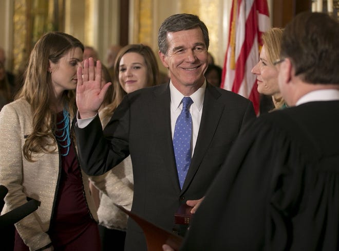 Roy Cooper is sworn in as governor of North Carolina by Chief Justice Mark Martin during a ceremony on Friday at the Executive Mansion in Raleigh.