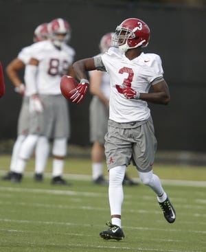 Alabama wide receiver Calvin Ridley tosses the ball to an assistant after making a catch during practice at the University of South Florida in Tampa, Fla., on Saturday. Staff Photo/Gary Cosby Jr.