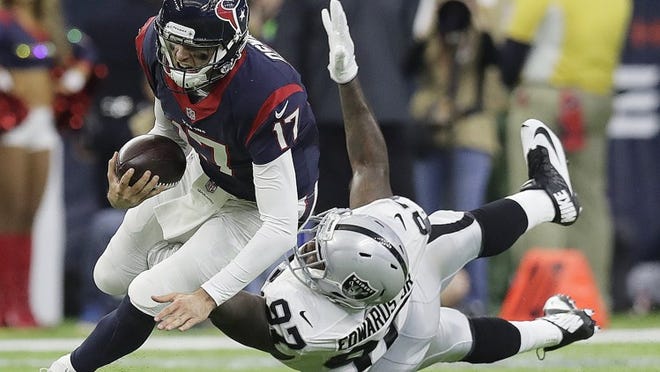 Houston Texans quarterback Brock Osweiler scrambles for a first down against Oakland Raiders defensive end Mario Edwards during the first half Saturday. (AP Photo/Eric Gay)
