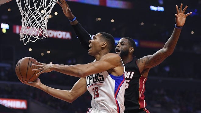 Los Angeles Clippers forward Wesley Johnson, left, shoots as Miami Heat forward Willie Reed defends during the first half of an NBA basketball game, Sunday, Jan. 8, 2017, in Los Angeles. (AP Photo/Mark J. Terrill)