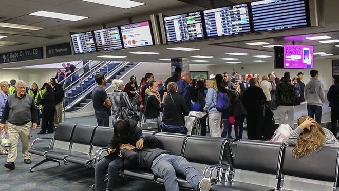 Travelers wait for checked baggage in Terminal 2 at the Ft. Lauderdale airport Sunday, January 8, 2017, where Esteban Santiago allegedly shot five people to death and injured six others Friday. Only a portion of the baggage claim area was open for use today, with the rest remaining blocked off by a large black curtain. Damon Higgins / The Palm Beach Post