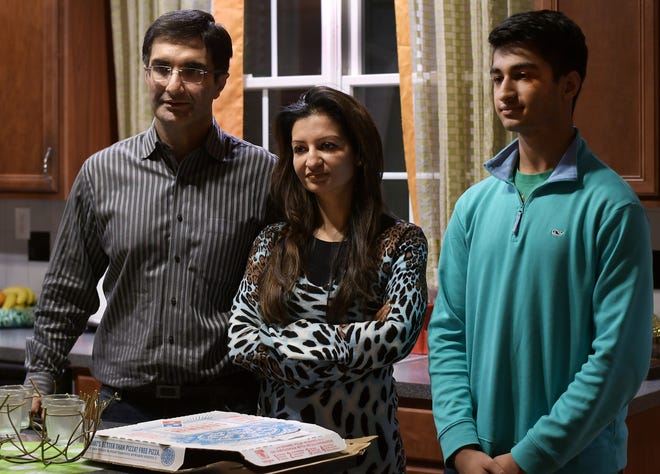 From left, Lokesh Khosla, his wife, Indu, and his son Syon at their home in Shrewsbury. The family said a pizza box with a racist comment was delivered to the house. T&G Staff/Christine Peterson