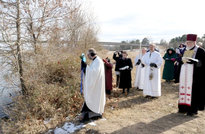 Sts. George and Alexandra Orthodox Church's Father Paul Fetsko, left, blesses the cross of ice before throwing it into the river Sunday, Jan 08, 2017, during the annual commemoration service, "The Blessing of the River," at Springhill Park in Barling. JAMIE MITCHELL/TIMES RECORD