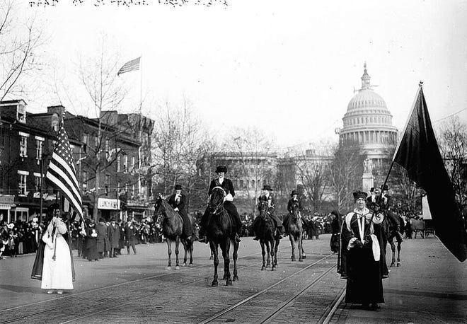 In this Library of Congress photo, women suffragists marching on Pennsylvania Avenue led by Mrs. Richard Coke Burleson (center, on horseback) with the U.S. Capitol in background.