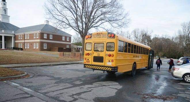 Students exit Bus No. 125 on Tuesday at First Baptist Church on Rouse Road. Children who are considered out of district riders are picked up at this site.