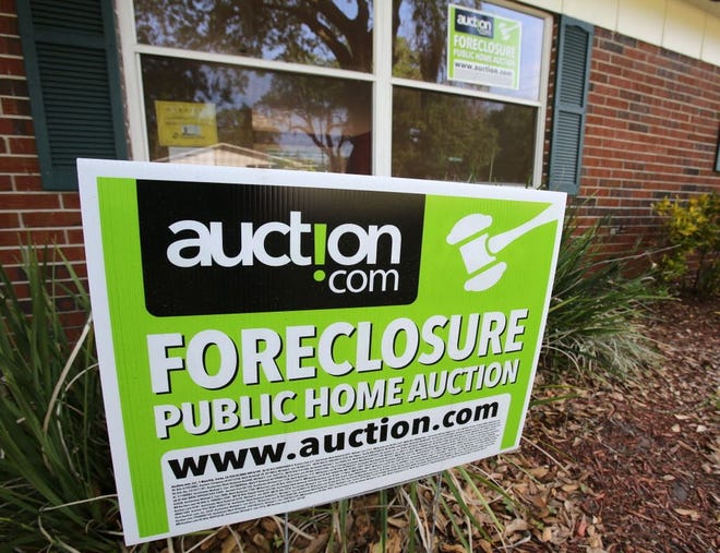 A sign announcing that a foreclosure home in Lakeland is for sale.