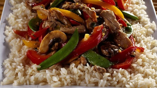 Pork, peppers, mushroom and pea pods make an easy stir-fry that’s even better with wine. (Bill Hogan/Chicago Tribune/TNS)