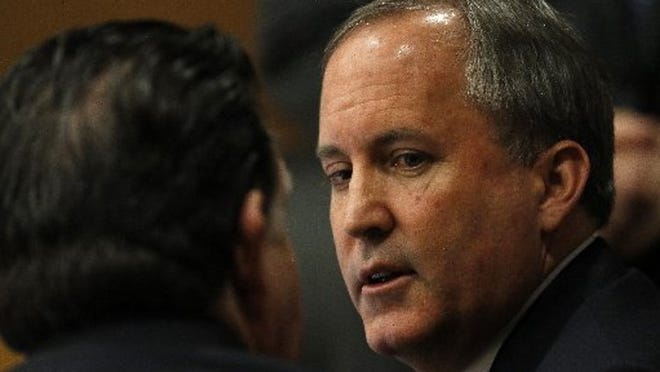 Texas Attorney General Ken Paxton speaks to one of his lawyers during a pretrial hearing in his criminal case.