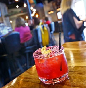 The signature "infused hibiscus" margarita which has tea, tequila and a real edible hibiscus.