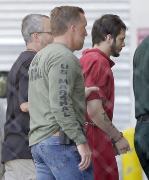 Esteban Santiago, right, accused of fatally shooting several people and wounding multiple others at a crowded Florida airport baggage claim, is returned to Broward County's main jail after his first court appearance, Monday, Jan. 9, 2017, in Fort Lauderdale, Fla. (AP Photo/Alan Diaz)