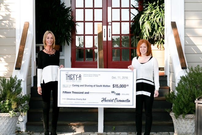 Harriet Crommelin, owner of Cafe Thirty-A, and Jessica Spicola, executive director of Caring and Sharing of South Walton, with the check donation. SPECIAL TO THE SUN