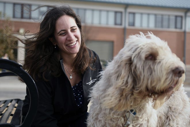 Francesca Tocco, a social worker at the Veterinary Health Center, sits with her dog, Lio, an Italian Spinone, Wednesday in front of the Veterinary Health Center. Tocco is the program coordinator for Together In Grief, Easing Recovery, an organization that comforts people whose dogs, cats or horses have died.