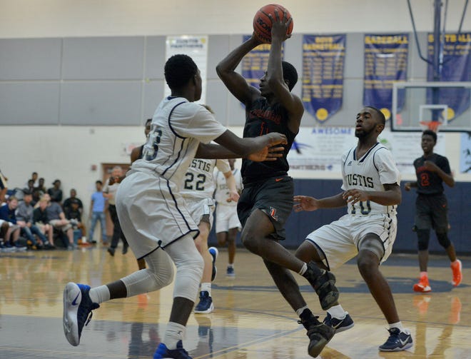 Leesburg's Cordrayius Graham (1) is guarded by a host of Eustis players during a game at Eustis High School on Dec. 6, 2016, in Eustis. Leesburg won the first meeting between the two teams in overtime. (Amber Riccinto/ Daily Commercial)