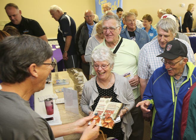Davide Hollinger, left, owner of Billy Bones restaurant, hands out information Friday at the Panama City Beach Senior Center. ANDREW WARDLOW/THE NEWS HERALD