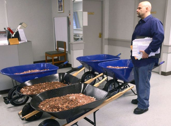 The Associated Press | Nick Stafford waits for his number to be called Wednesday, Jan. 11, 2017, as he stands beside of 5 wheelbarrows full of change, mostly pennies, at the DMV in Lebanon, Va. Stafford was paying the sales tax on two cars that he was titling. Stafford had paid $165 to file three lawsuits in Russell County General District Court: two against specific employees at the Lebanon DMV and one against the DMV itself., which means he spent $1,005 to get 10 phone numbers and the satisfaction of delivering 300,000 pennies. Not to mention the nearly $3,000 he paid the DMV for the cars. (David Criggeru/The Bristol Herald)