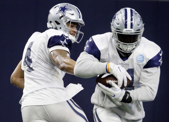 Dallas Cowboys running back Ezekiel Elliott (21) takes the handoff from quarterback Dak Prescott (4) during NFL football practice at the team's headquarters on Wednesday. The Cowboys host the Packers at 4:40 p.m. on Sunday. (AP Photo/LM Otero, File)
