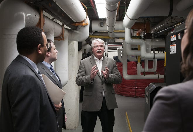 Director of maintenance Gary Saltmarsh gives a tour of the boiler room in Canterbury Towers, an energy-efficient building, in Worcester on Thursday. T&G Staff/Rick Cinclair