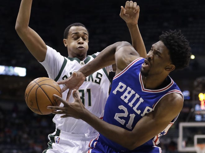 Sixers Joel Embiid loses the ball as he drives past Milwaukee's John Henson during the first half of Monday's game in Milwaukee. Embiid scored 12 of his 22 points in the fourth quarter as the Sixers held off the Bucks.