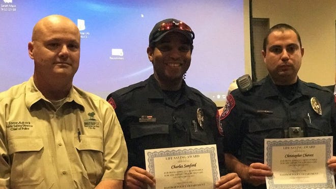 Bastrop Police Chief Steve Adcock (left) recognizes officer Monty Sanford and Cpl. Chris Chavez for saving a woman from her burning apartment on Jan. 4. (MARY HUBER/BASTROP ADVERTISER)