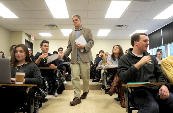 Craig Palmer, associate professor of cultural anthropology at the University of Missouri, hands out syllabi Tuesday to students in his People of Canada class. Spring semester classes opened Tuesday after Gov. Eric Greitens on Monday said he was cutting state funds for higher education because of low revenue.