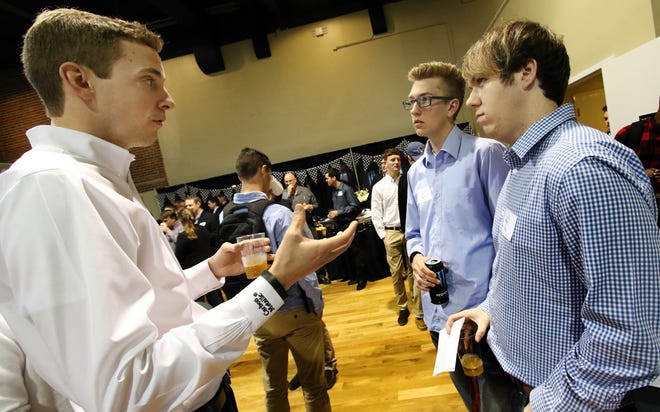 Belmont Abbey College hosted its inaugural motorsports symposium in the Haid Ballroom on Tuesday morning to help students make connections with the motorsports industry for job placement after graduation. From left, Justin Cockerham, with PFC Brakes, talks with Abbey students Trey Hedgecock and Ayrton Parris during a networking break. MIKE HENSDILL/THE GAZETTE