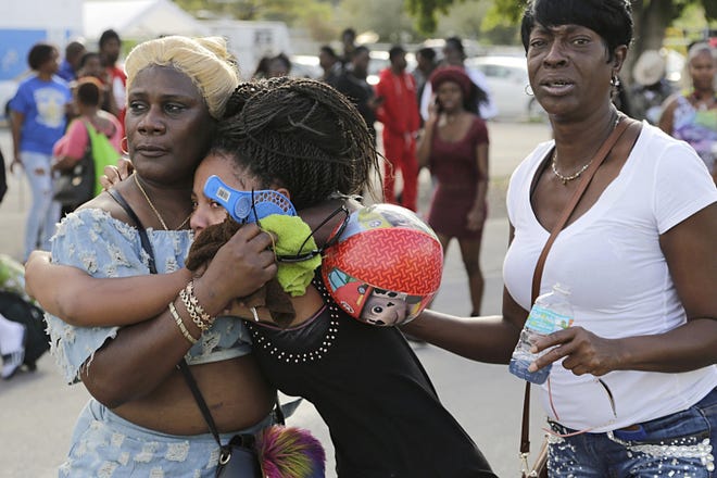 People react after several were injured in a shooting at Martin Luther King Jr. Memorial Park in Miami-Dade Monday. (Carl Juste/Miami Herald via AP)