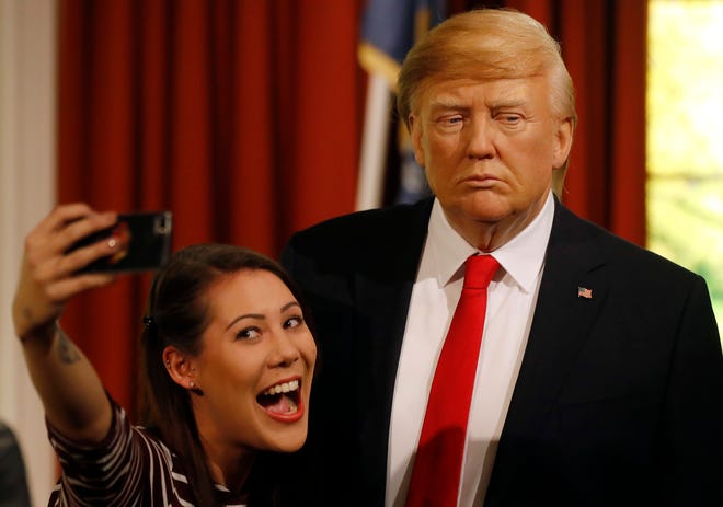 Madame Tussauds’ employee Helen Smith taks a selfie next to the wax figure of US President-elect Donald Trump, as they unveil the figure just days ahead of the American’s Presidential Inauguration in Washington in London, Wednesday, Jan. 18, 2017. The figure will now reside in Madame Tussauds’ London Oval Office alongside fellow famous politicians and global icons also immortalised in wax. (AP Photo/Frank Augstein)