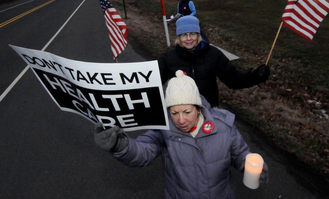 Sharon Roth, of Medford, and Cidnie Richards, of Tabernacle, protest during a candlelight rally for the Affordable Care Act outside the Gibson House in Evesham where U.S. Rep. Tom MacArthur has an office, on Wednesday, Jan. 18, 2017.