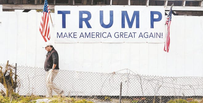 Watson Sutton, owner of Sutton Brick Company, walks past the "Make America Great Again" sign he had custom made in support of Donald Trump on Wednesday on Park Avenue. Sutton plans on watching the inauguration and is looking forward to changes Donald Trump will make.