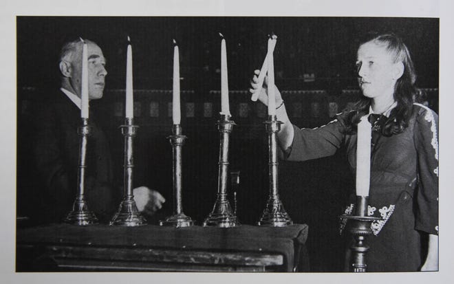 Janine Lew, then Janine Putter, at age 13, lights a memorial candle at a protest prayer service held in New York's Mecca Temple on Feb. 22, 1943. The photo appears in a book called "The Holocaust Chronicle." 



Herald-Tribune staff photo / Rachel S. O'Hara