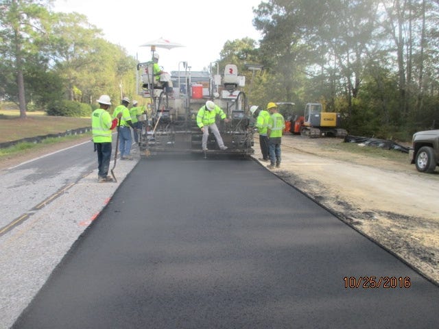 Workers are shown putting thefinishing touches on the repaving of County Road 285 in Walton County. SPECIAL TO THE DAILY NEWS