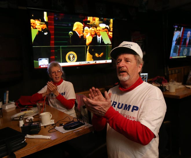 Lane County Republican Central Committee Chair Wayne Lemler (right) celebrates as he watches Donald Trump takes the oath of office during an inauguration watch party at The Keg Tavern in Eugene. (Chris Pietsch/The Register-Guard)