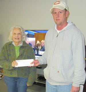 Ellen Burbage, left, with the Humane Society of Logan County, accepts a check from Scott Billington, P&M's Operations Manager. Photo submitted