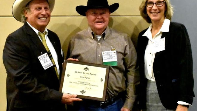 Jerry Ingram, center, was recently recognized for 20 years of service to the Bastrop SWCD. He was presented with a plaque by Jos Dodier, left, and Vicki Riser. PHOTO BY JOSH DECAMP