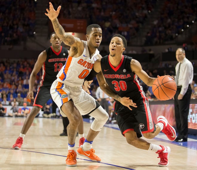 Georgia guard J.J. Frazier (30) dribbles past Florida guard Kasey Hill (0) during the second half of an NCAA college basketball game in Gainesville, Fla., Saturday, Jan. 14, 2017. Florida won in overtime 80-76. (AP Photo/Ron Irby)