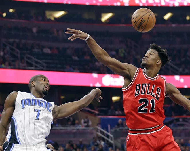 Orlando Magic's Serge Ibaka, left and Chicago Bulls' Jimmy Butler go after a rebound that bounced off the rim during the first half of an NBA basketball game on Tuesday in Orlando, Fla. (AP Photo/John Raoux)