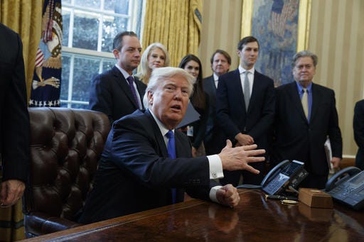 President Donald Trump talks with reporters n the Oval Office of the White House in Washington, Tuesday, Jan. 24, 2017, before signing an executive order on the Keystone XL pipeline.