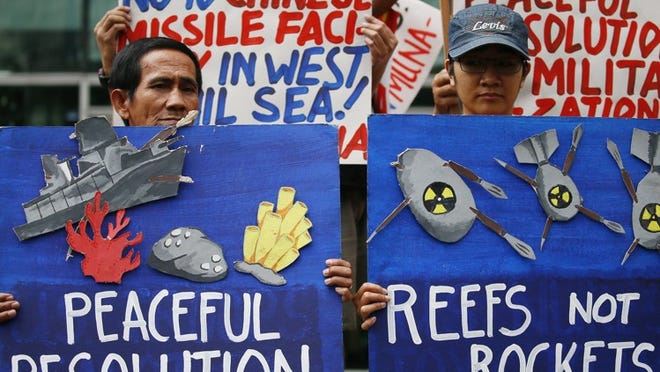 Environmental activists in Manila display placards Tuesday as they picket the Chinese Consulate to protest alleged military build-up by China on the disputed group of islands at the South China Sea.