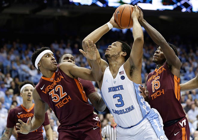 North Carolina's Kennedy Meeks drives to the basket against Virginia Tech's Zach LeDay (32) and Chris Clarke.